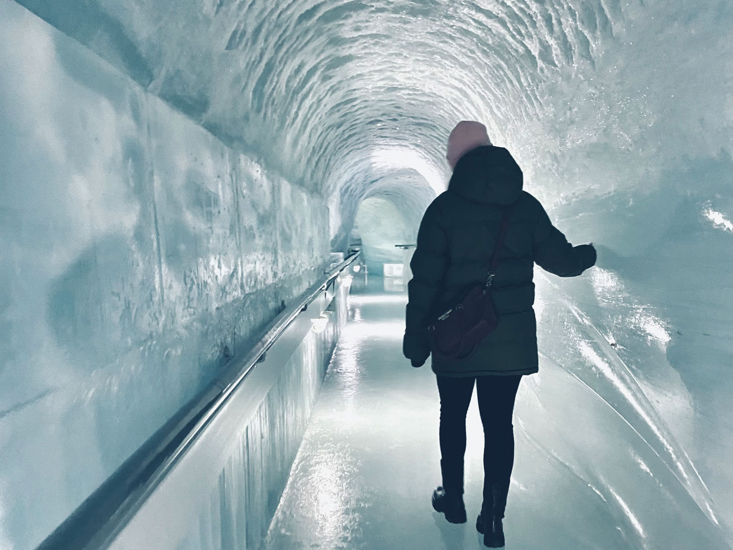 Eine Frau die im Eispalast vom Jungfraujoch läuft.