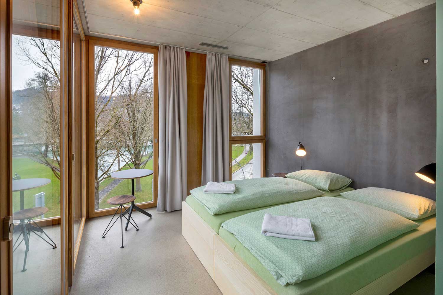 Ein Doppelbett in der Jugendherberge Bern mit Aussicht auf die Aare.